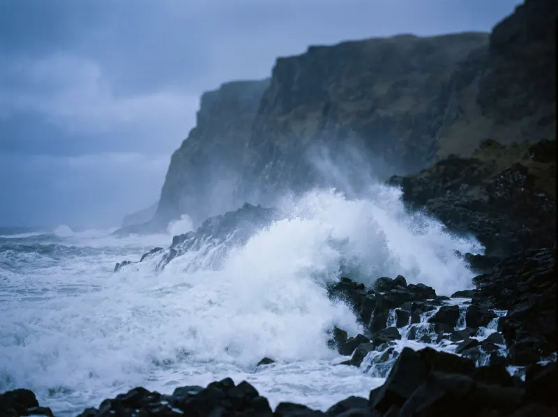 Waves breaking under an open cliff